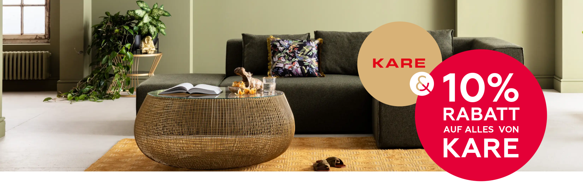 10% auf KARE Banner plus eine schwarzes KARE-Sofa  vor einer grünen Wand.